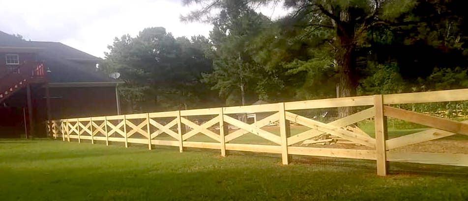 Photo of wood horizontal rail fence with wire mesh between the horizontal slats