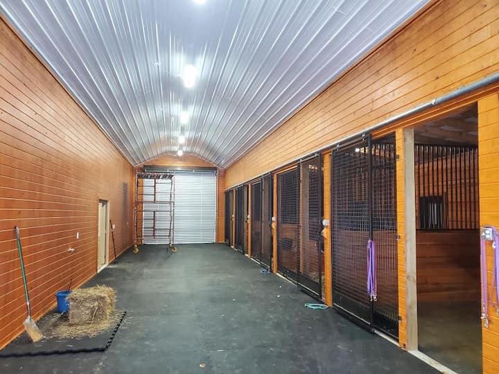 Photo of metal gate with metal electric fence framed with wood posts and rails