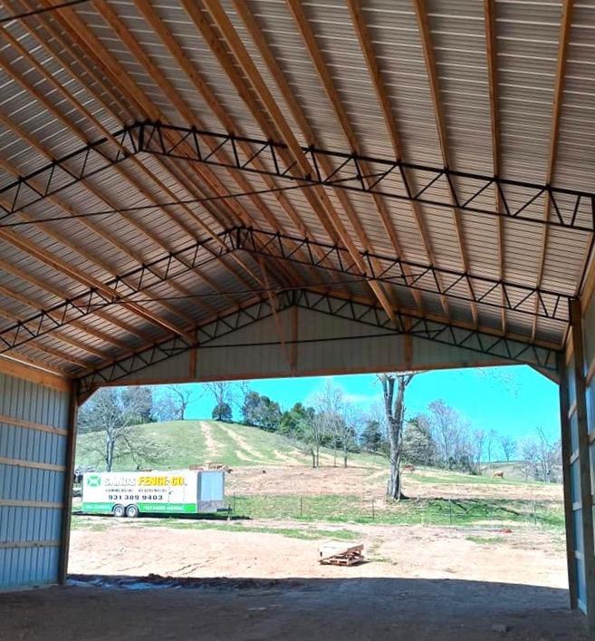 Photo of metal gate with metal electric fence framed with wood posts and rails