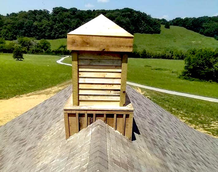 Photo of wood venting structure on top of a chimney of a home