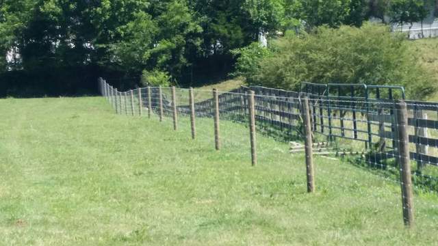 Photo of mesh fence. This fence has wood round fence poles and the actual barrier of the fence is wire mesh
