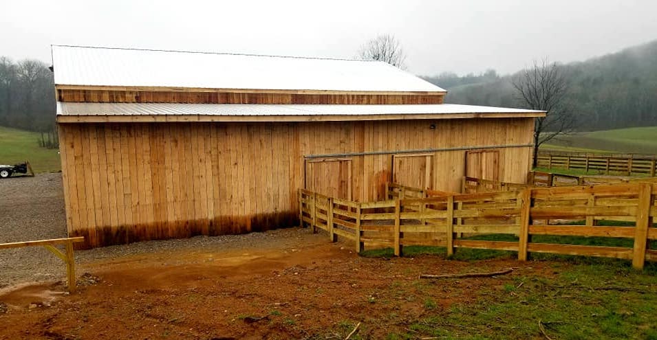 Photo of metal gate with metal electric fence framed with wood posts and rails