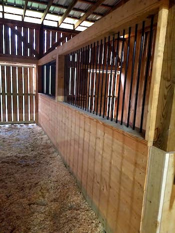 Photo of metal gate with metal electric fence framed with wood posts and rails