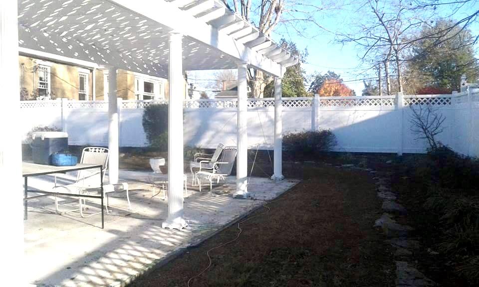 Photo of driveway with wood fence on either side. The fence is a wood fence with two horizontal slats and an upper "x style" slat.