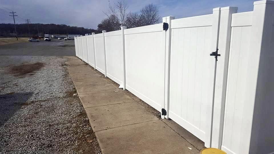 Photo of driveway with wood fence on either side. The fence is a wood fence with two horizontal slats and an upper "x style" slat.