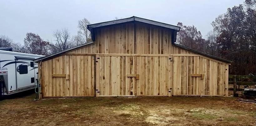 Photo of metal gate with metal electric fence framed with wood posts and rails