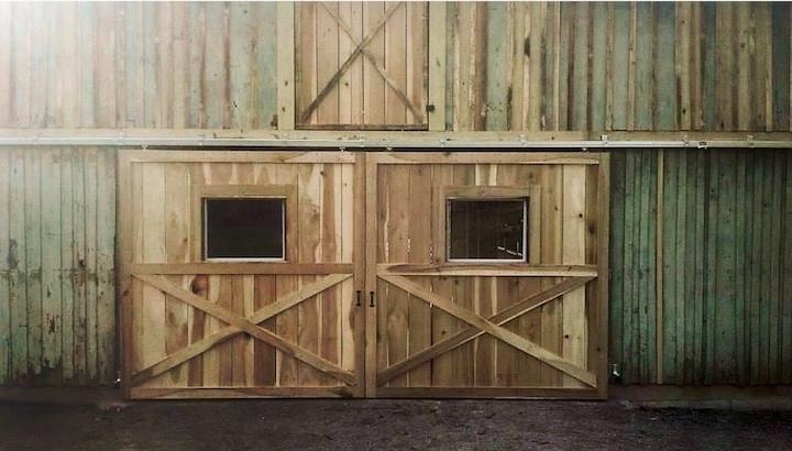 Photo of metal gate with metal electric fence framed with wood posts and rails