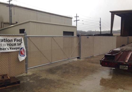 Photo of driveway with wood fence on either side. The fence is a wood fence with two horizontal slats and an upper "x style" slat.